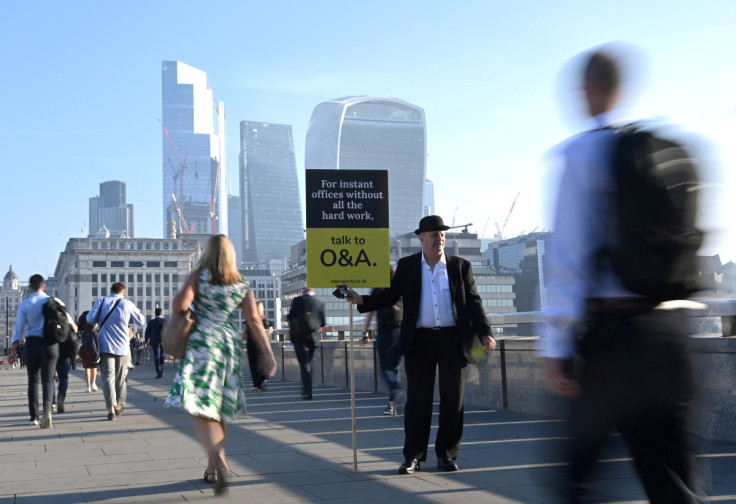 Workers walk towards the City of London financial district as they cross London Bridge during the morning rush hour in London