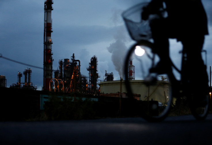 A bicycle rider rides past a factory at Keihin industrial zone in Kawasaki