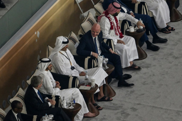 FIFA President Gianni Infantino (C) chats with Saudi Arabia's Crown Prince Mohammed bin Salman (R), wearing a scarf in Qatari colours, and Qatar's Emir Sheikh Tamim bin Hamad al-Thani (4th L) on World Cup opening day