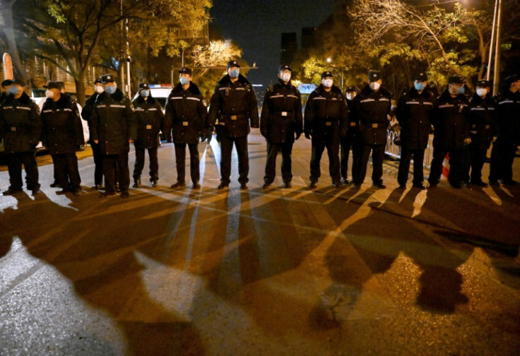 Police kept a watchful eye over a rally in Beijing held for the victims of a deadly fire and in protest against China's harsh anti-Covid policies