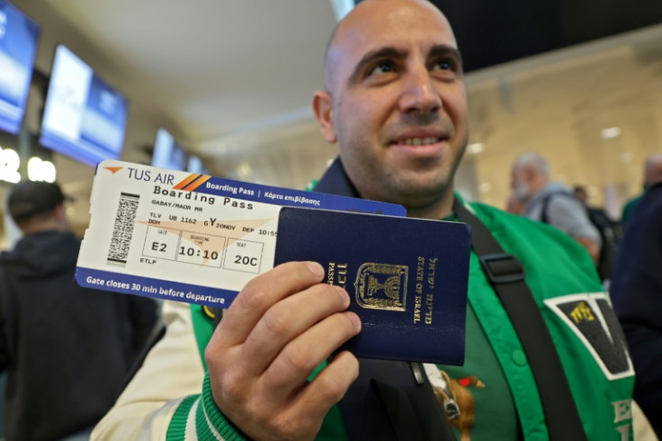 An Israeli football fan shows his passport and air ticket before boarding a special flight to Doha for the World Cup -- where Israeli symbols have stayed hidden