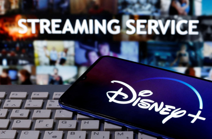 Smartphone with displayed "Disney" logo is seen on the keyboard in front of displayed "Streaming service" words in this illustration