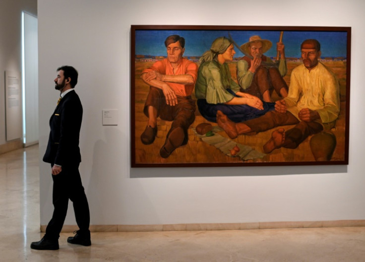 A gallery assistant stands near 'Rest' by Oleksandr Syrotenko at the 'In the Eye of the Storm' exhibition