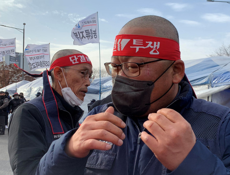 Unionised truck drivers wear headbands during a head-shaving protest to oppose President Yoon Suk-yeol issuing a back-to-work order for the striking truckers in Uiwang