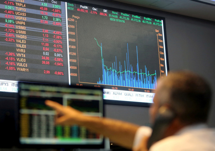 A man points to electronic board showing fluctuations of market indices at the floor of Brazil's BM&F Bovespa Stock Market in Sao Paulo