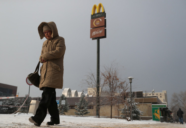 A woman walks past a closed McDonald's restaurant in Almaty