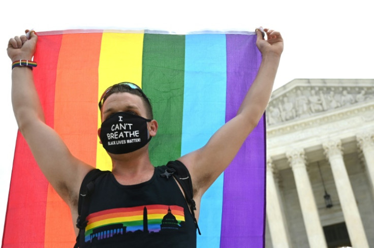 A man hoists a rainbow flag outside the US Supreme Court on June 15, 2020