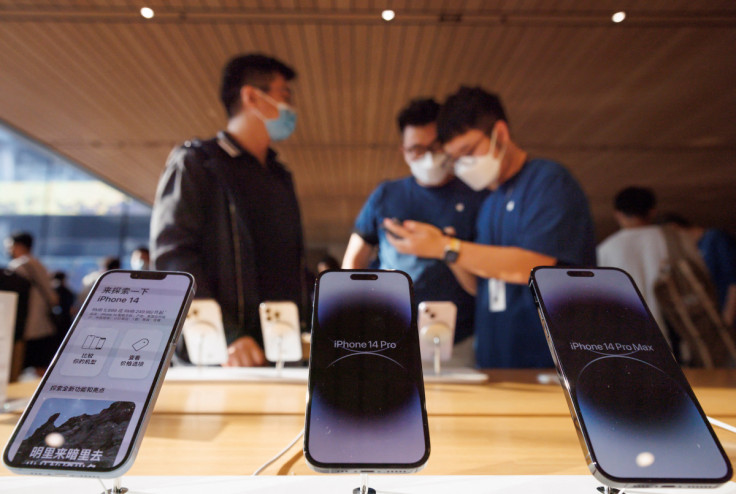 A customer talks to sales assistants in an Apple store as Apple Inc's new iPhone 14 models go on sale in Beijing