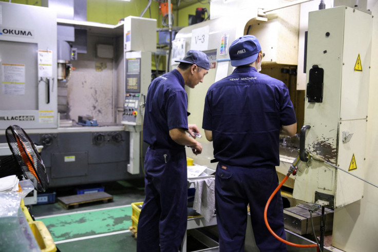 Workers check the machinery at the factory of aircraft component manufacturer Aoki in Higashiosaka