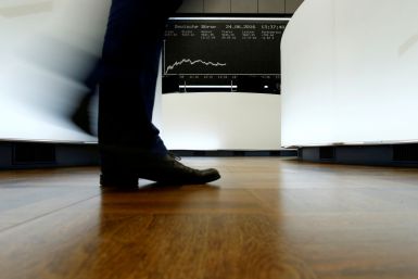 A trader walks past the German DAX Index board on the trading floor at the Frankfurt stock exchange