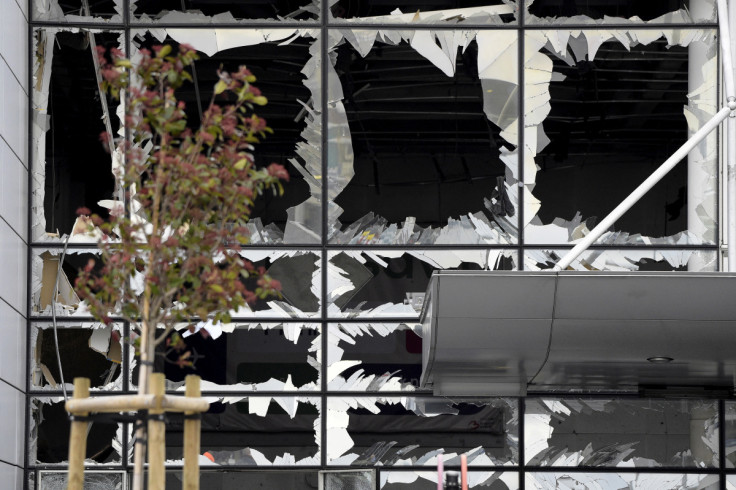 Broken windows of the terminal at Brussels national airport are seen during a ceremony following bomb attacks in Brussels metro and Belgium's National airport of Zaventem