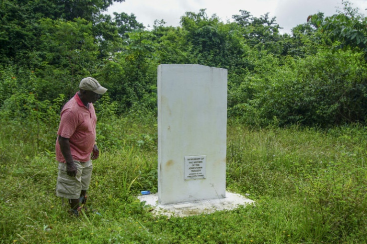 Fitz Duke, who lives in nearby Port Kaituma village, stands in front of a nondescript memorial stone, the only sign of the grisly Jonestown massacre