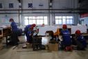 Employees work on assembling automated guided vehicles (AGV) at Lonyu Robot Co in Tianjin