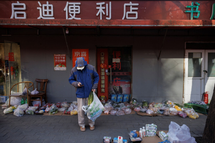 A man picks his grocery purchases in a street as many shops remain closed because of coronavirus disease (COVID-19) curbs in Beijing