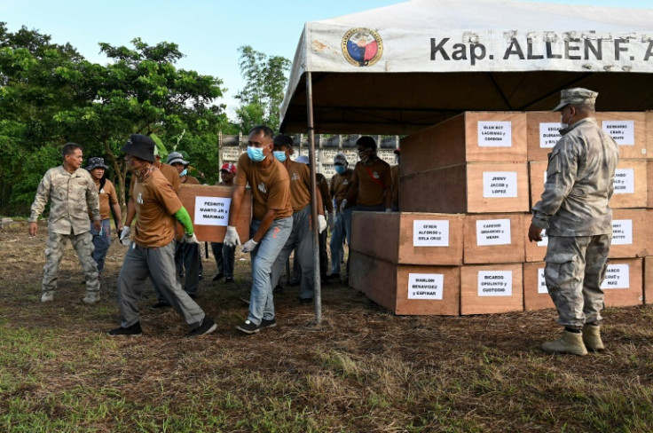 Minimum security inmates carry the 70 plywood coffins to their final resting place -- cheap concrete tombs in a cemetery inside the prison complex