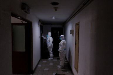 Pandemic prevention workers in protective suits knock on a resident's door in an apartment building that went into lockdown as coronavirus disease (COVID-19) outbreaks continue in Beijing