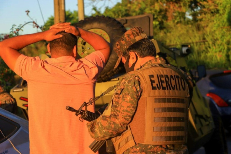 A Salvadoran soldier searches a man during a major government operation against gangs in the city of Soyapango on December 3, 2022