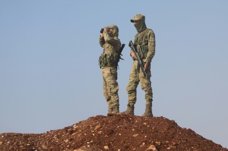 Turkish-backed Syrian fighters keep watch on the front line with Kurdish forces in Tal Rifaat, awaiting orders from Turkish President Recep Tayyip Erdogan on whether to proceed with a threatened ground offensive