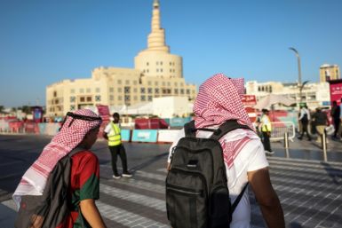 Football fans walk near the Sheikh Abdulla bin Zaid Islamic Cultural Center in Doha
