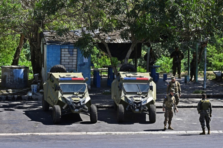 Soldiers stand guard during a raid against gang members in the Salvadoran city of Soyapango on December 4, 2022