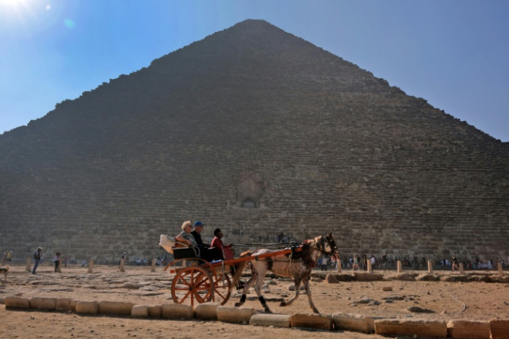 The Giza pyramids remain popular for more traditional tourism too: here people ride in a horse-drawn cart past the ancient Egyptian king Khufu's Great Pyramid