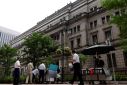 People buy their lunches from street vendors in front of the headquarters of Bank of Japan in Tokyo