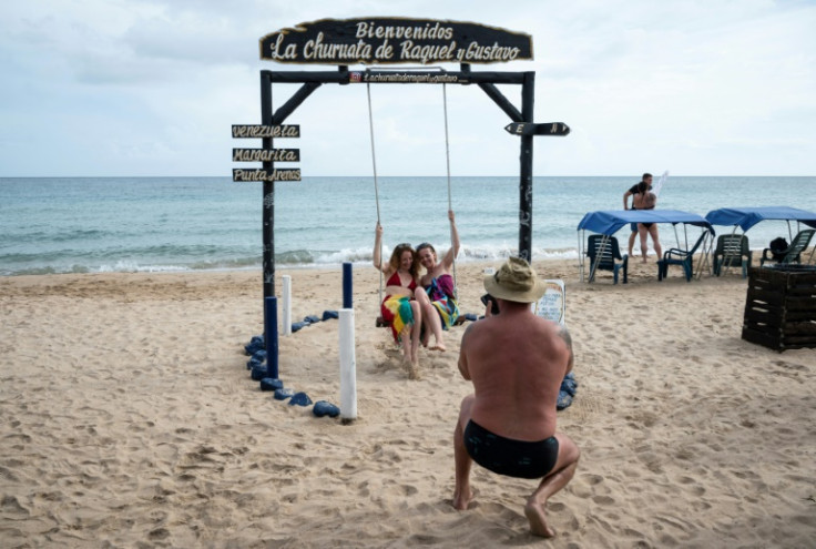 Russian tourists pose for photos at Punta Arenas beach in Venezuela during a guided tour of Isla Margarita