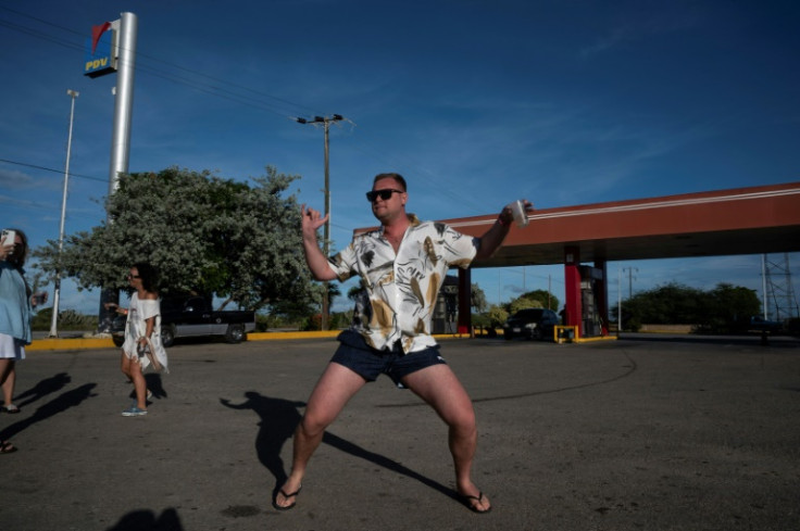 In a holiday mood, Russian tourist Dimitri Bobkov dances during a stop at a gas station on the Isla Margarita