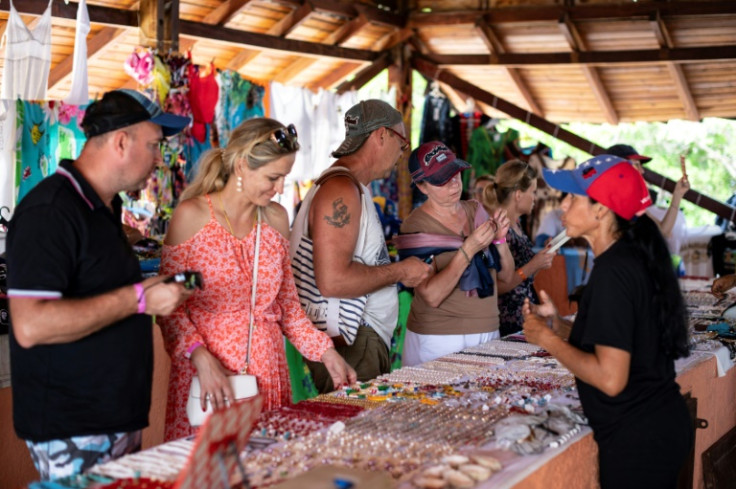 A group of Russian tourists buys local crafts and jewelry from Venezuelan vendors on Isla de Margarita. The island has become a hotspot for tourist from Russia, who have few travel options due to sanctions over the Ukraine war