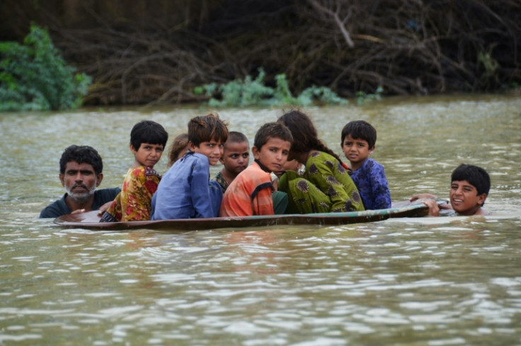 Pakistanis use a satellite dish to move children across a flooded area in Jaffarabad district of Balochistan in August 2022