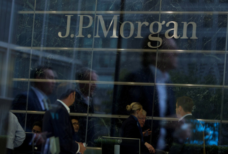 Workers are reflected in the windows of the Canary Wharf offices of JP Morgan in London