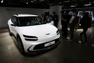 Members of the media take photographs of a Genesis GV60 electric vehicle during its showcase in Seoul