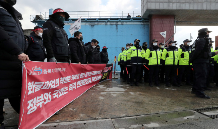 Policemen are deployed in front of a cement factory while unionized truckers holds a campaign for their strike in Danyang