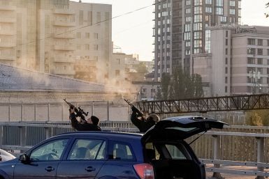 Police officers shoot at a drone during a Russian drone strike in Kyiv