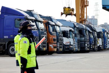 Police officers walk past a parked truck at a terminal of the Inland Container Depot in Uiwang