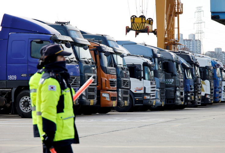 Police officers walk past a parked truck at a terminal of the Inland Container Depot in Uiwang