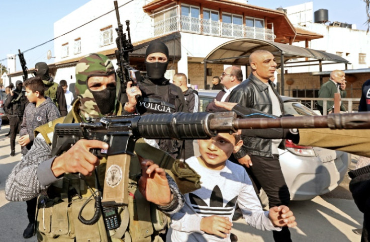 Palestinian gunmen take part in the funeral procession of three Palestinians killed by Israeli forces during a West Bank raid