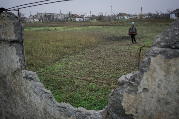 Local resident Liudmyla Hupalo stands near destroyed buildings in the village of Posad-Pokrovske