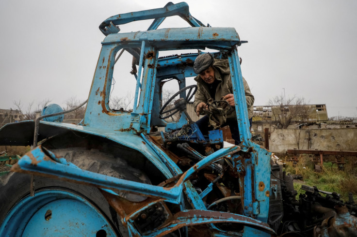 Local farmer Oliinyk inspects his damaged tractor in the village of Posad-Pokrovske