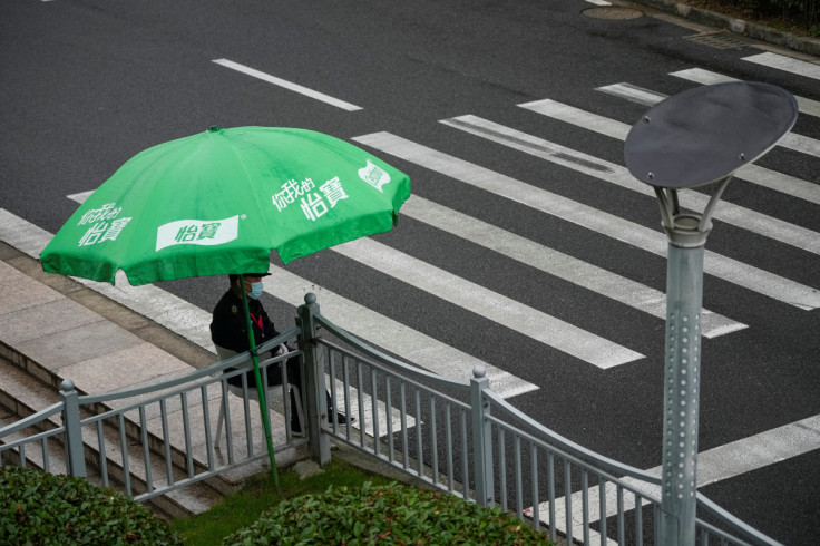 A security guard wearing a face mask keeps watch of a street at Lujiazui financial district in Shanghai