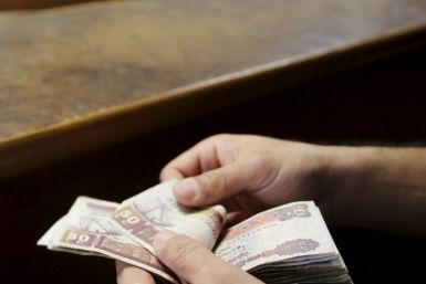 A customer counts his Egyptian 50 pound notes at an exchange office in downtown Cairo