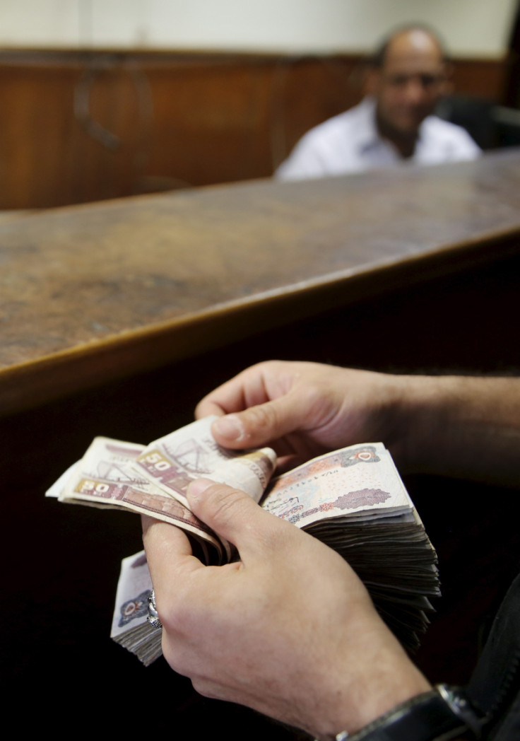 A customer counts his Egyptian 50 pound notes at an exchange office in downtown Cairo