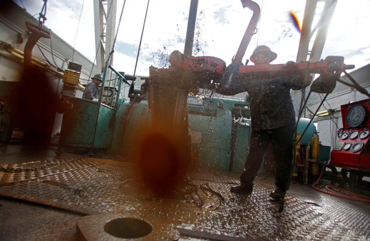 Roughnecks wrestle pipe on an oil drilling rig outside Watford