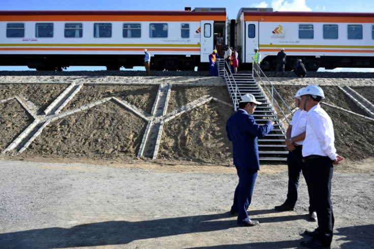 Chinese builders stand next to the Standard Gauge Railway train at Mai Mahiu, Kenya, in October 2019