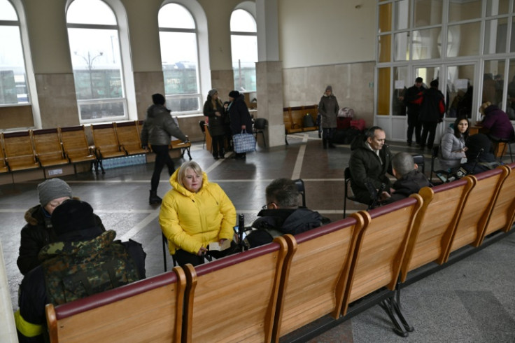 Ukrainian policemen check passengers' documents before their departure on an evacuation train, at Kherson's train station on December 8, 2022