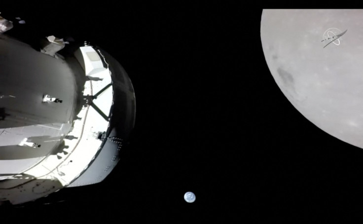 Camera on Orion's solar array wing captures a view of the spacecraft, the Earth and the Moon