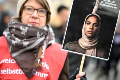 A demonstrator in Berlin holds a poster in solidarity with 'women in danger of death,' after Iran carried out its first execution linked to the protests in the Islamic republic