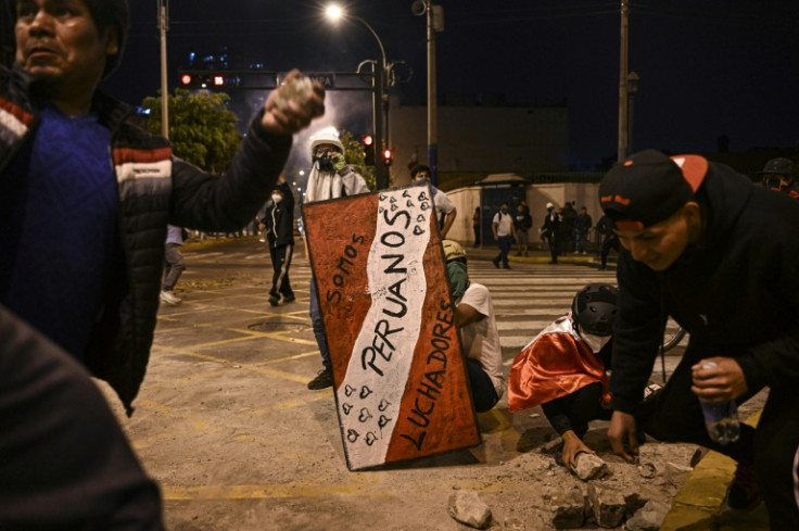 Supporters of ex-president Pedro Castillo prepare to hurl rocks at police near Congress in Lima on December 12, 2022
