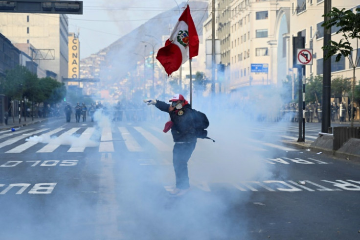 A cloud of acrid tear gas envelops a supporter of ex-president Pedro Castillo protesting near Congress in Lima