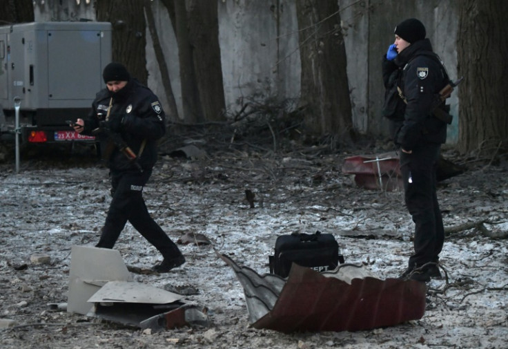 Rescuers and police experts examine remains of a drone following a strike on an administrative building in the Ukrainian capital Kyiv